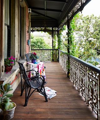 deck railing with wooden floor and chairs and potted plants