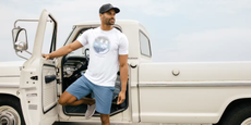 Man standing in front of a truck with a TravisMathew T-shirt on
