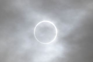 ring of light behind gray clouds.