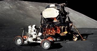 Apollo 17 mission commander Eugene Cernan drives the lunar roving vehicle during the early part of the first moonwalk at the Taurus-Littrow landing site. The lunar module is in the background.
