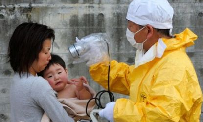 A Japanese medic checks out a mother and son last week for radiation exposure.