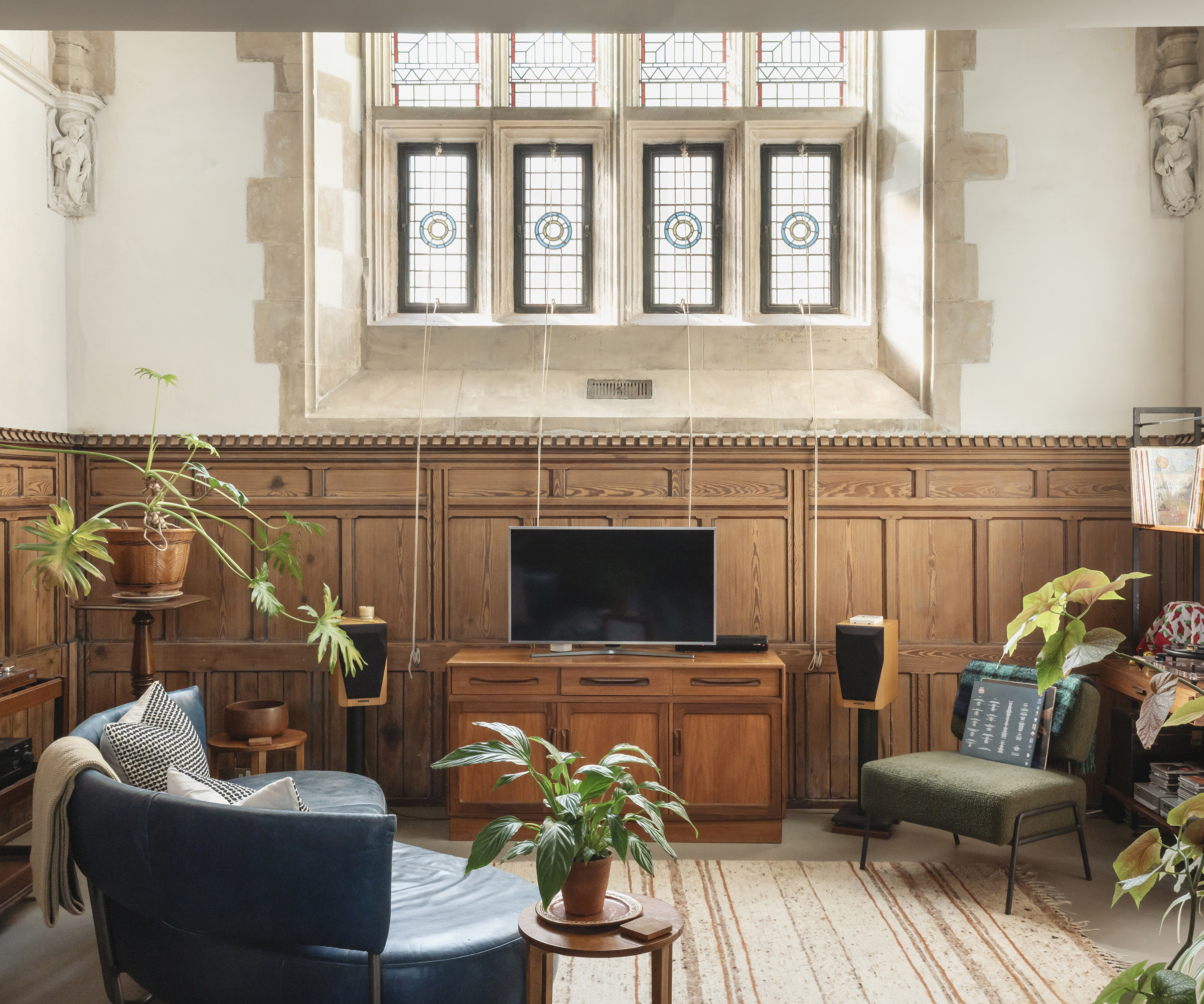 A living room in a newly converted church building with original wood panelling