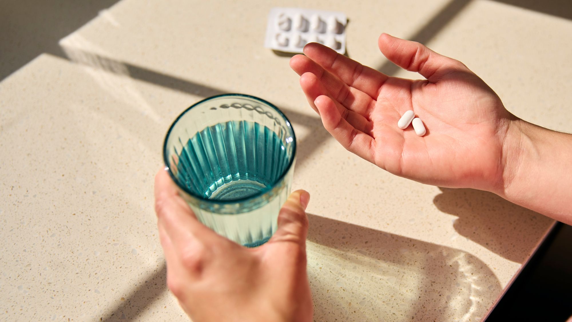 Probiotics for women: Young woman talking supplement by table
