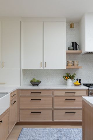 Oak kitchen units and white wall units with a white countertop and backsplash