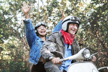 Senior couple riding a classic scooter