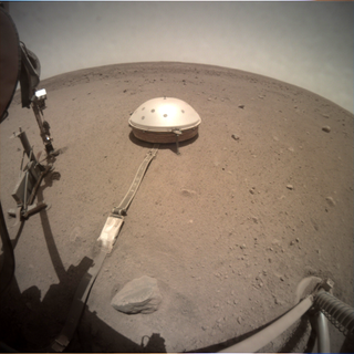 A photograph of InSight's seismometer, as seen on Apr. 24, 2020, the day of and shortly after a Phobos transit.