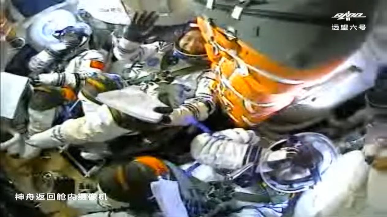 China's Shenzhou 12 commander Nie Haisheng waves in the center seat after reaching orbit on June 17, 2021. The mission is China's first crewed flight to its new space station.
