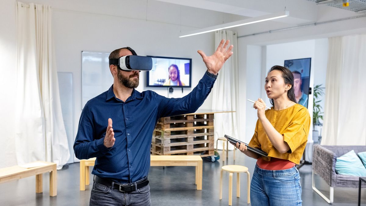 A man and a woman work in an office, creating new concepts using a Meta headset within the metaverse.