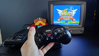 retro-bit wireless Genesis controller being held in front of Japanese Mega Drive and CRT with Sonic 2 on screen