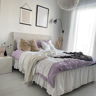 Relaxed, feminine bedroom with soft gray foundation, and relaxed bedlinen in layers of relaxed neutrals and lilac.