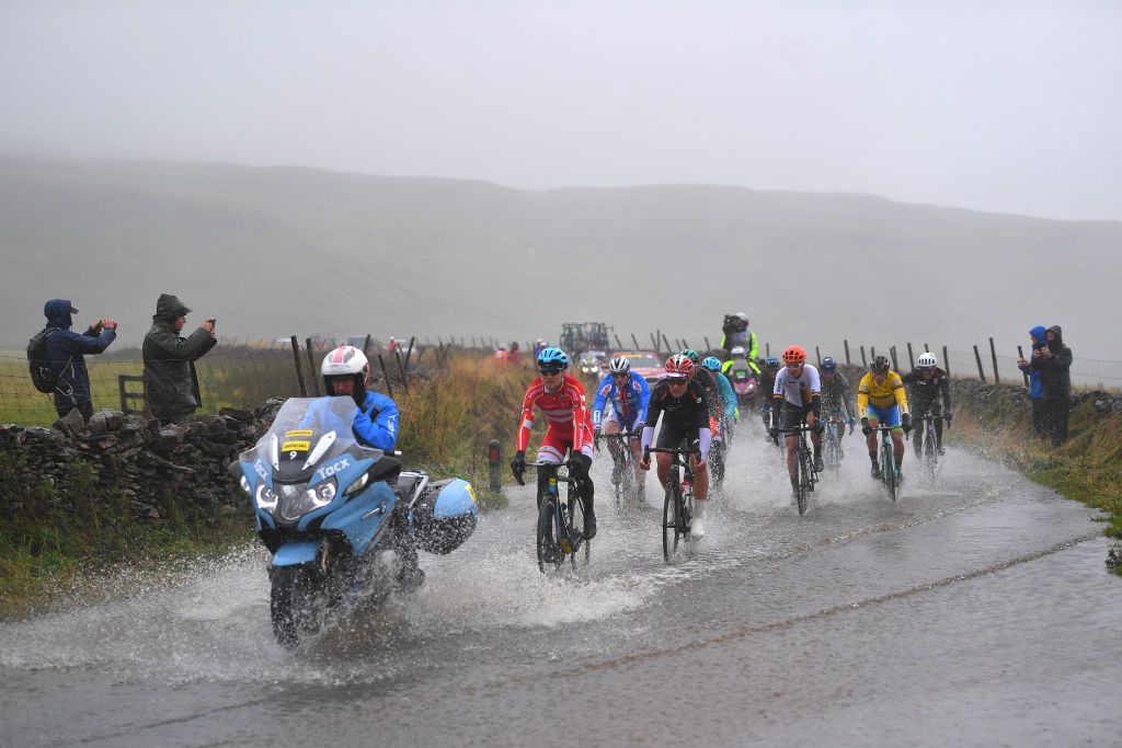 The day's early break gets its feet wet on a very wet section of the course