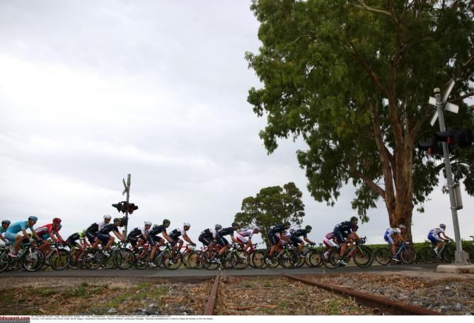 The peloton crosses the train tracks