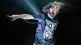 Lamb Of God's Randy Blythe onstage screaming and pointing