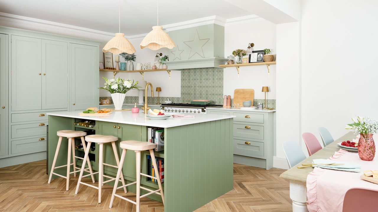 Green kitchen with large island and wooden floor