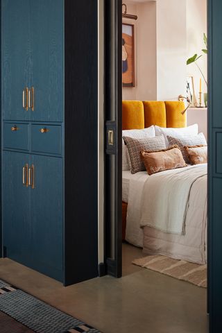 A bedroom with blue door and pink walls