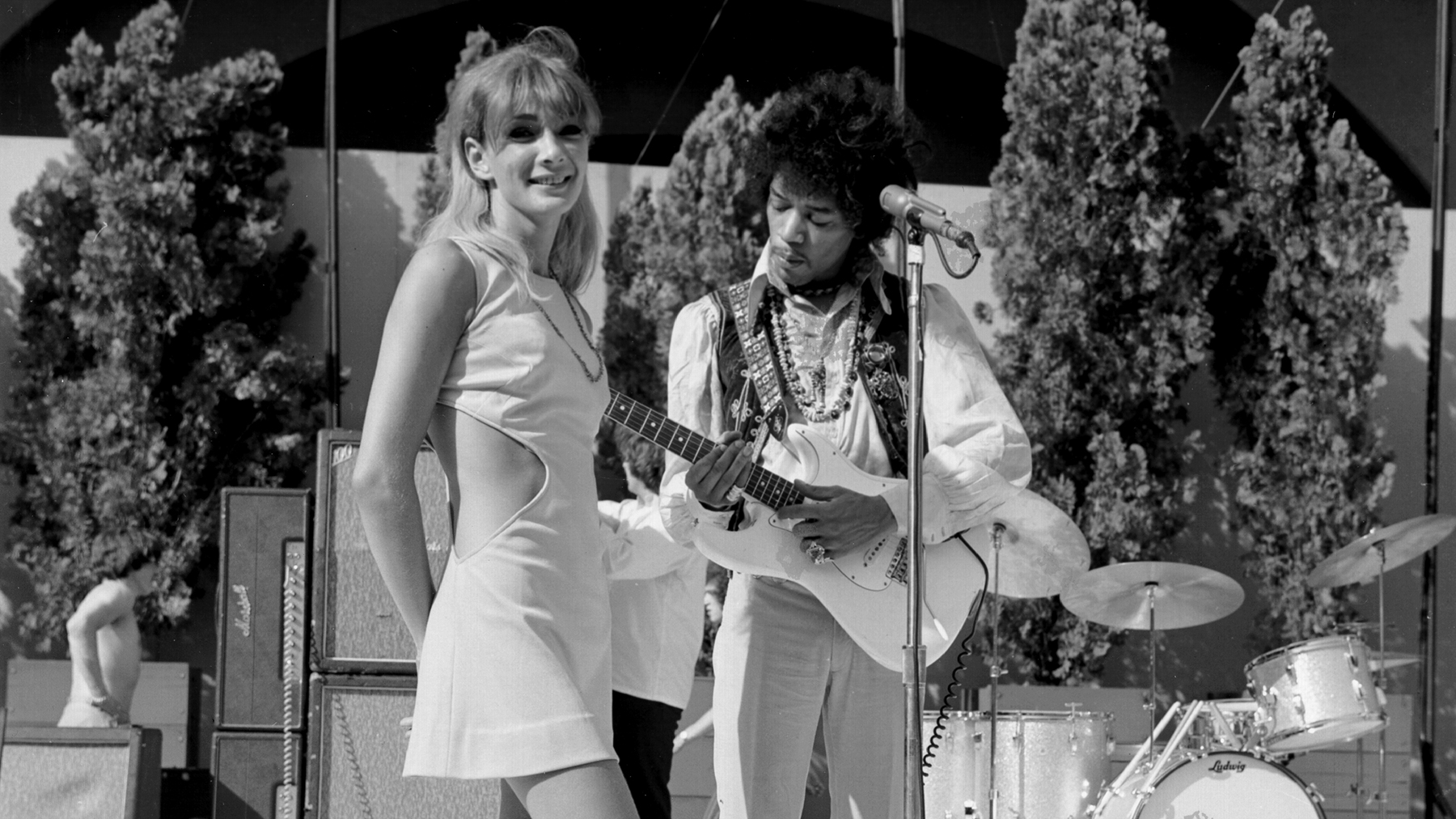 Jimi Hendrix plays his Fender Stratocaster electric guitar onstage as a woman looks on during soundcheck for his performance at the Hollywood Bowl on August 18, 1967 in Los Angeles, California.