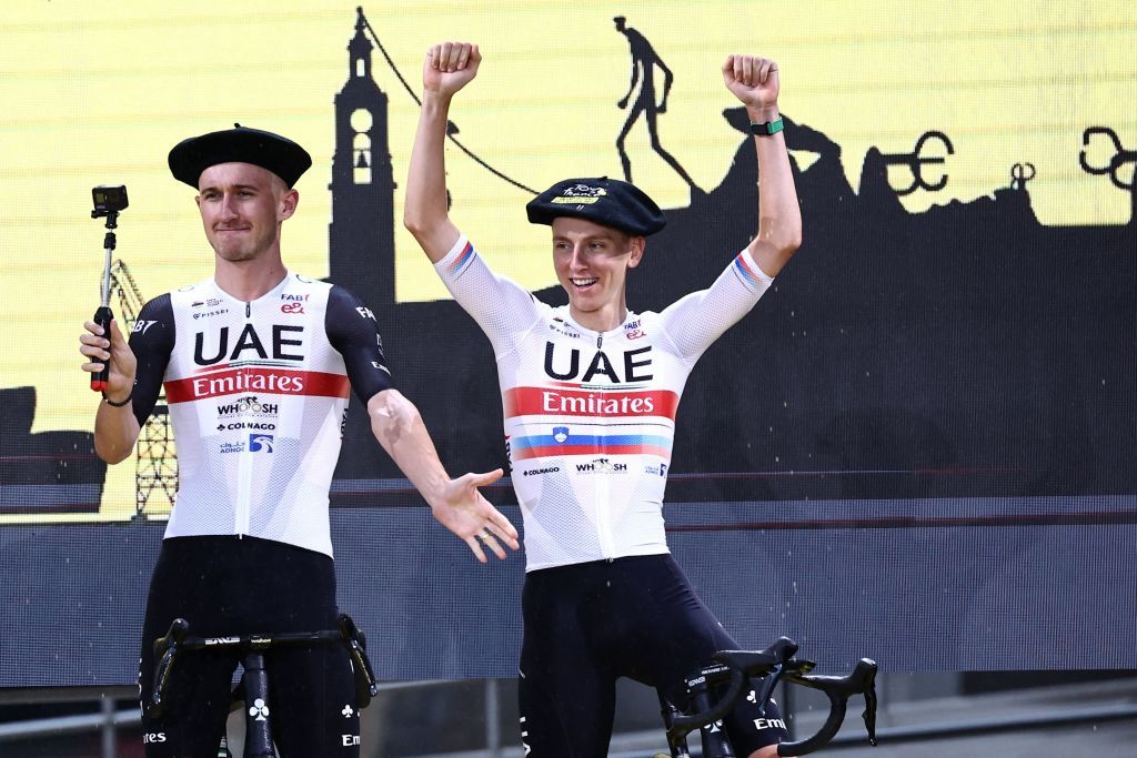 UAE Team Emirates Danish rider Mikkel Bjerg L points to UAE Team Emirates Slovenian rider Tadej Pogacar R as they take to the stage during the official teams presentation near the Guggenheim Museum Bilbao in Bilbao northern Spain on June 29 2023 two days prior to the start of the 110th edition of the Tour de France cycling race Photo by AnneChristine POUJOULAT AFP Photo by ANNECHRISTINE POUJOULATAFP via Getty Images