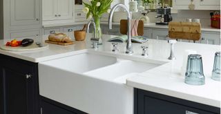 Navy blue kitchen island with white counters and double sink
