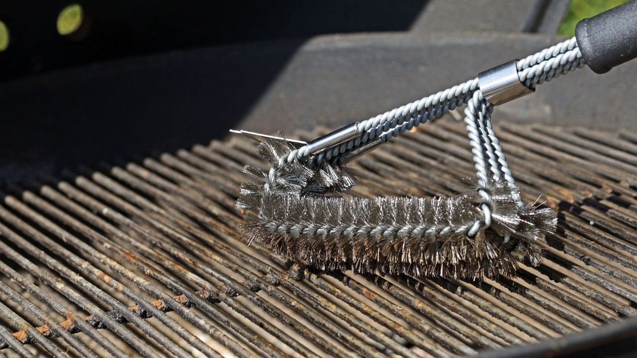 A wire grill brush cleaning a grill