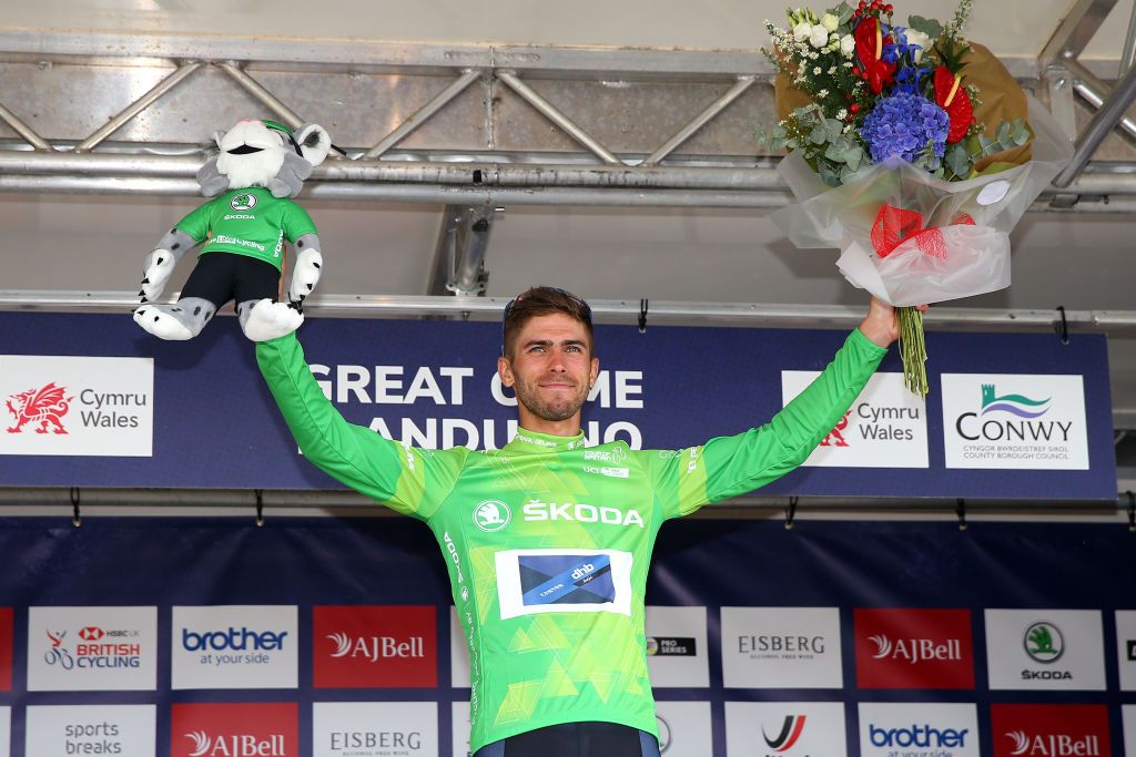 LLANDUDNO SEPTEMBER 08 Jacob Scott of United Kingdom and Team Canyon DHB Sungod celebrates winning the green mountain jersey on the podium ceremony after the 17th Tour of Britain 2021 Stage 4 a 210km stage from Aberaeron to Great Orme Llandudno 1306m TourofBritain TourofBritain on September 08 2021 in Llandudno United Kingdom Photo by Alex LiveseyGetty Images