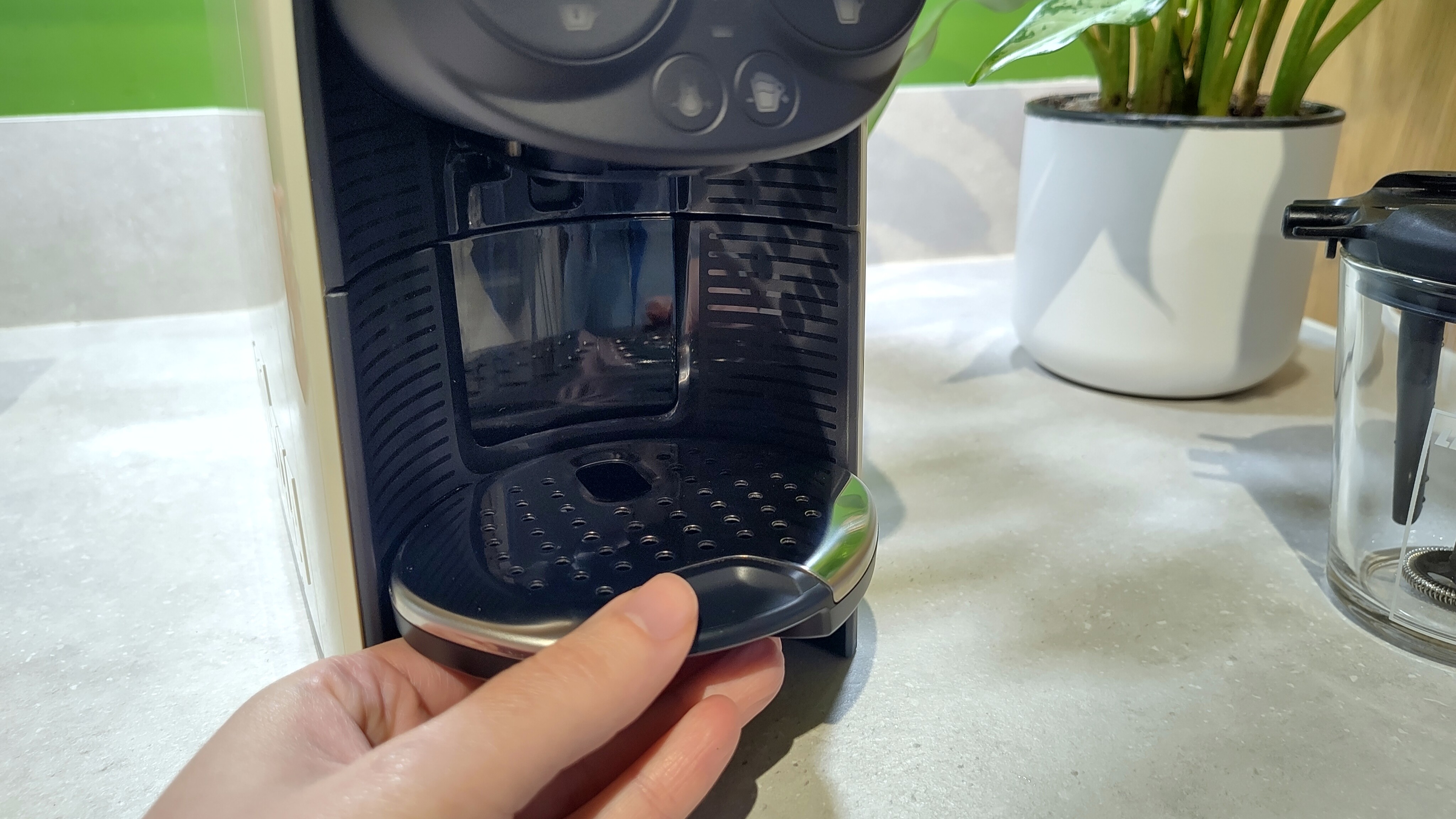 Person adjusting height of drip tray on Lavazza A Modo Mio Des&eacute;a coffee maker