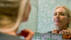 Woman looking at self in mirror