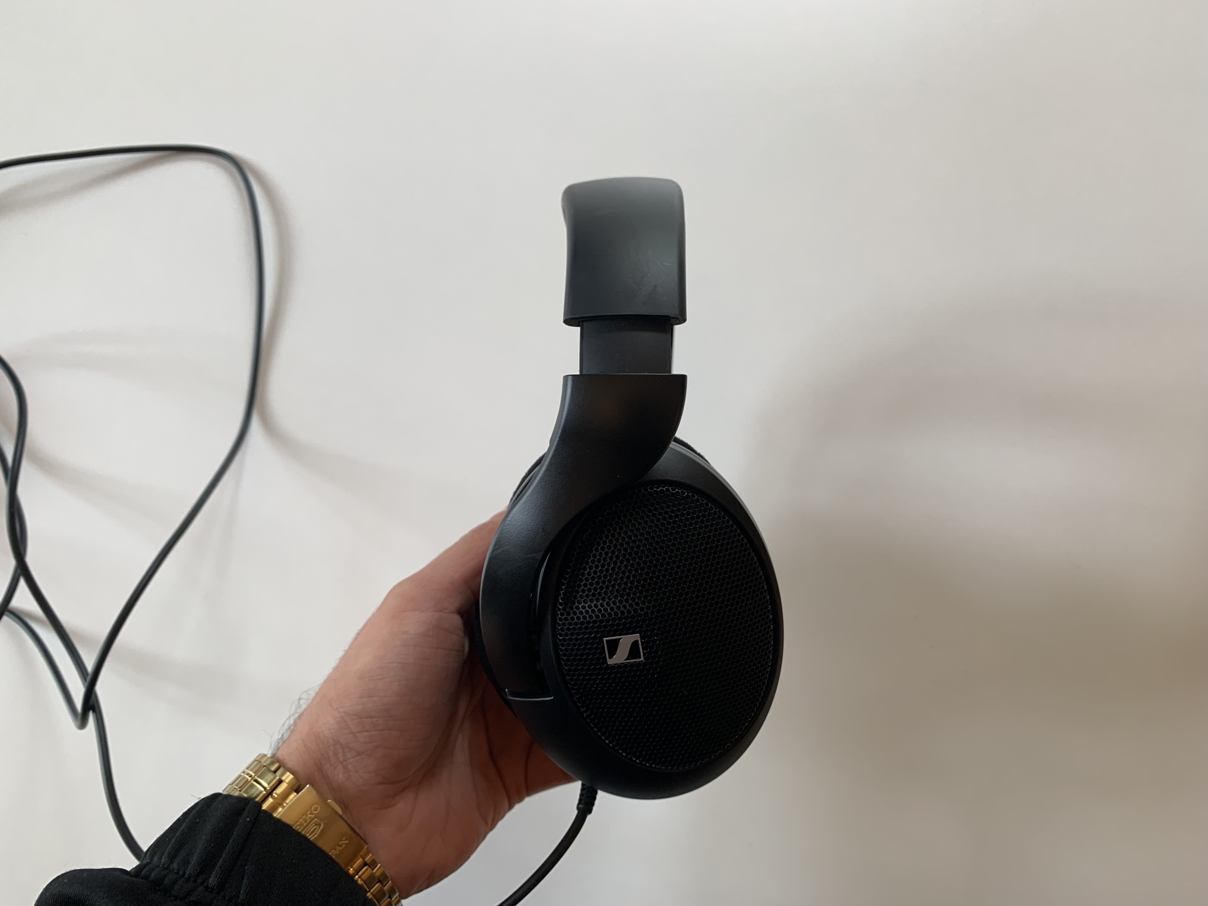 Sennheiser HD 560S in der Hand über einem weißen Tisch