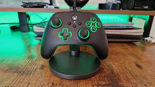 PowerA Advantage Controller review image of the gamepad sitting against a stand with green lighting on