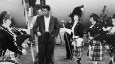 Muhammad Ali is greeted by pipers from plane in Scotland