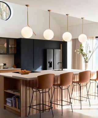 cream, black and wooden kitchen with raised section along length of kitchen island