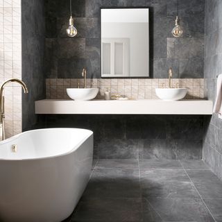 bathroom with bathtub graphite stone wall and floor and wash basin