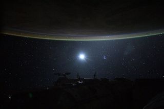 The moon lights up the star-filled night sky as an effect called "airglow" gives Earth's atmosphere a subtle green glow in this photo taken by an astronaut at the International Space Station. This green luminescence is the result of interactions between atmospheric particles and ultraviolet radiation coming from the sun.