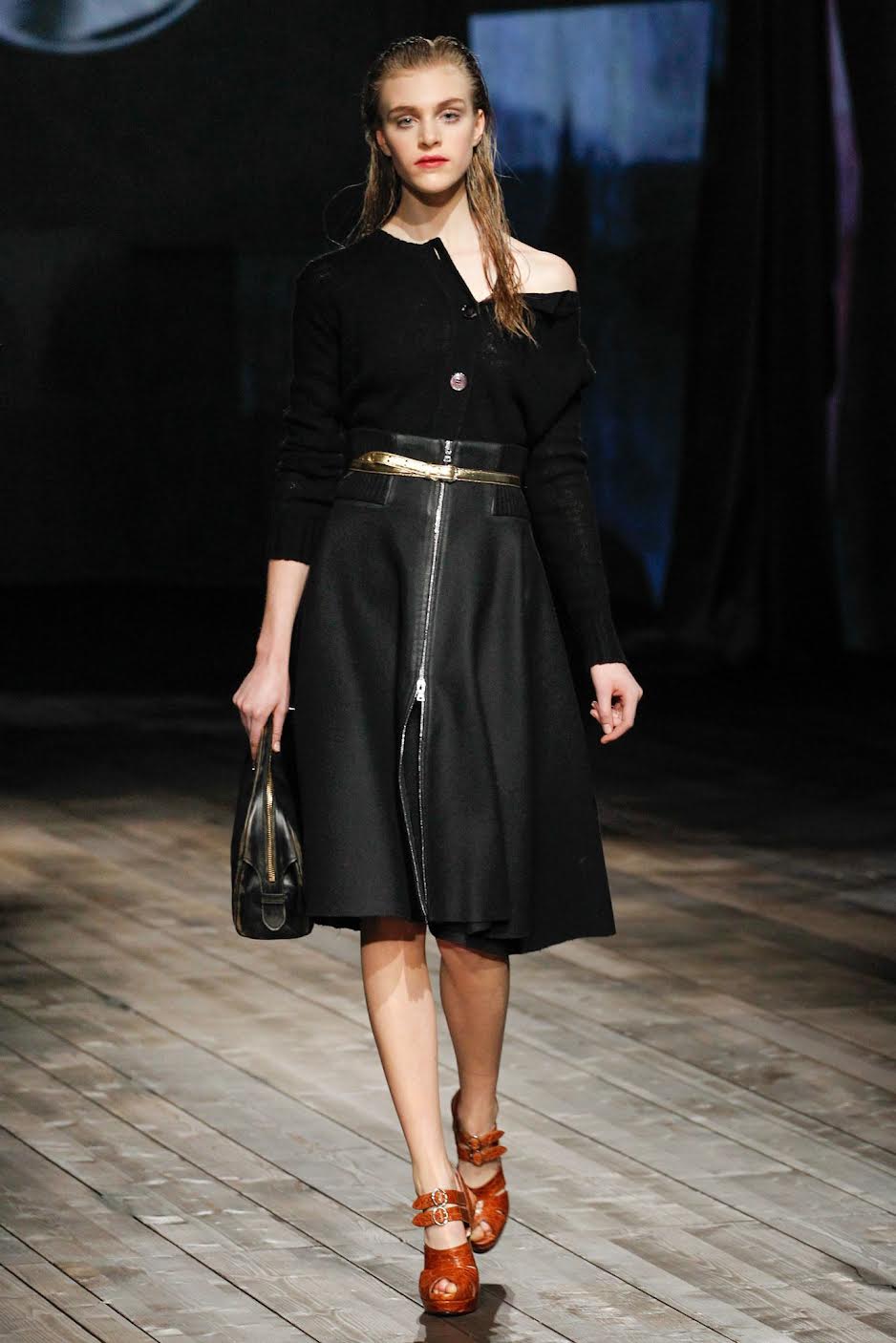 a model walking in the Prada Fall 2013 show wearing a black thin knit cardigan with a black skirt