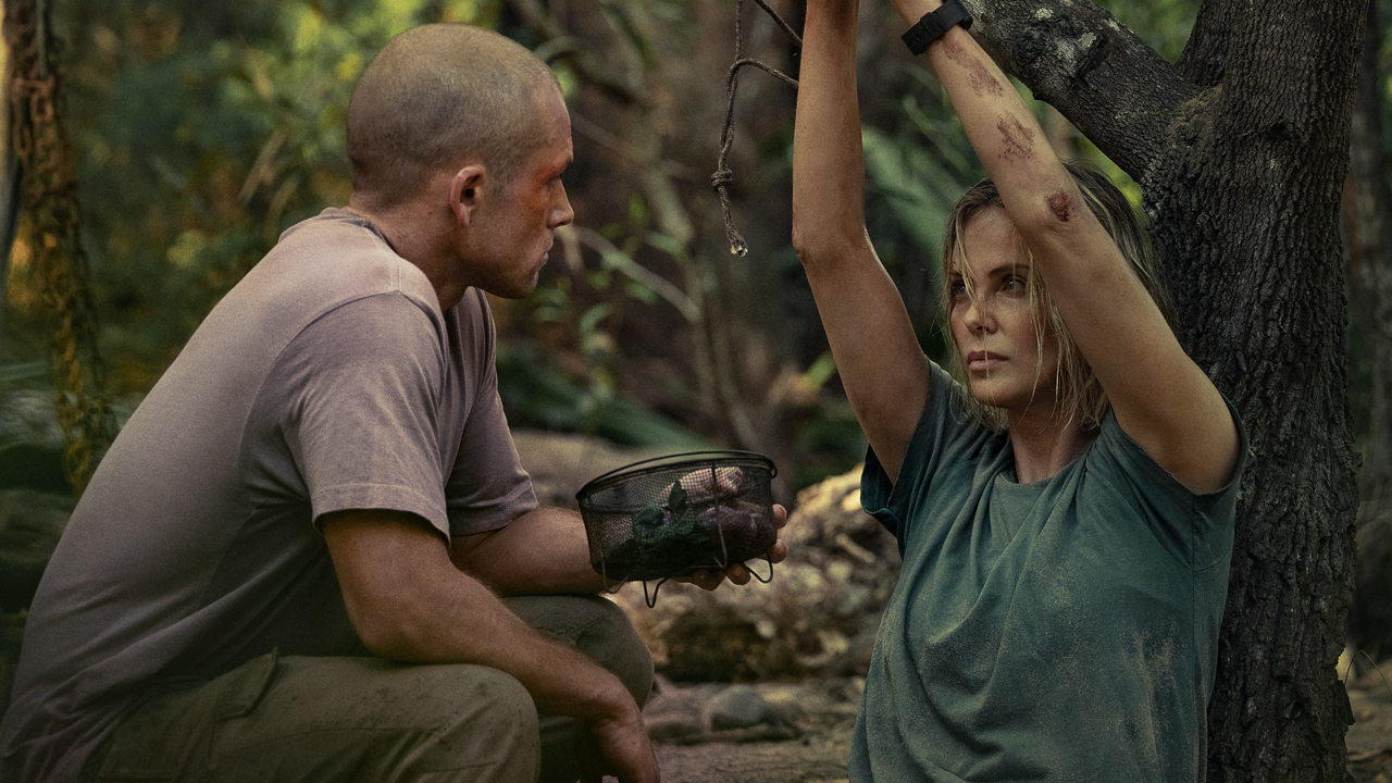 Taron Egerton with Charlize Theron tied up in the wilderness in Apex