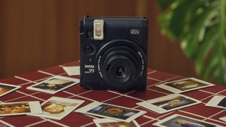 Fujifilm Instax Mini 99 sobre una mesa de azulejos con mini impresiones