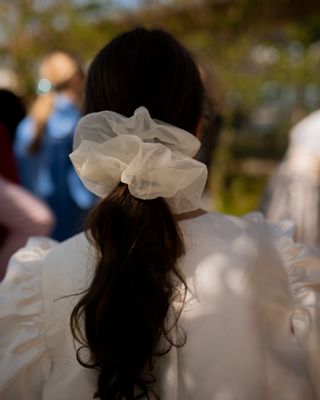 A woman at Copenhagen Fashion Week wears an oversized hair tie with a matching top