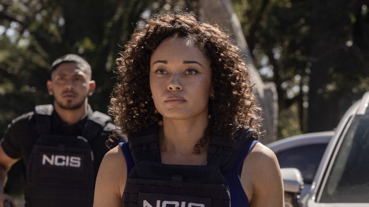 Michelle Mackey wearing her bulletproof NCIS Sydney vest with DeShawn walking behind her