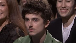 Timothée Chalamet looks angry as he watches Kenan Thompson give a speech on SNL.