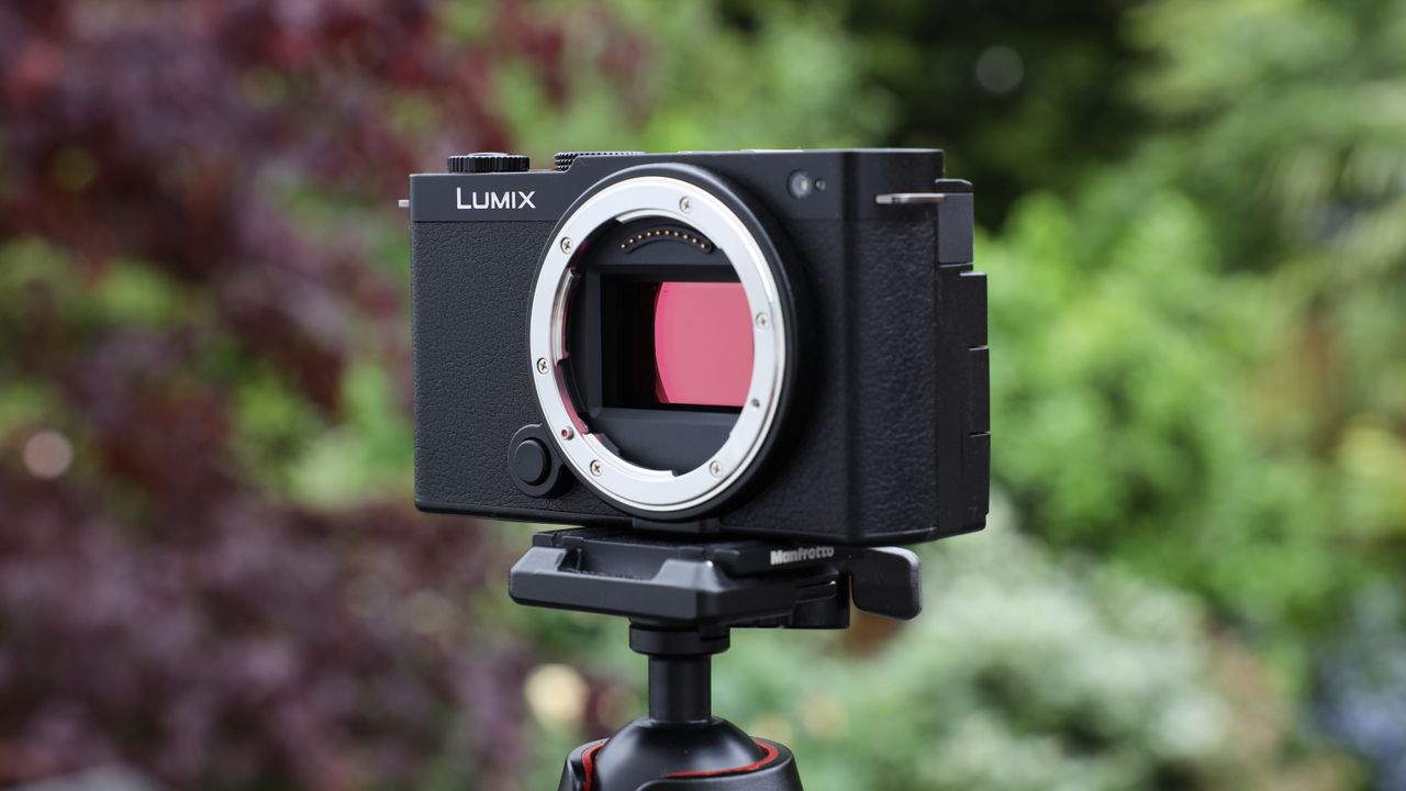 Panasonic Lumix S9 camera on a tripod outside in front a green bush