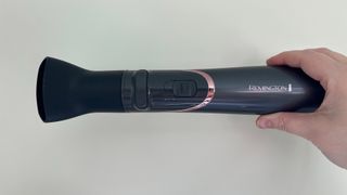 The Remington Curl and Straight Confidence Airstyler AS8606 being heldf in a hand with the drying attachment connected