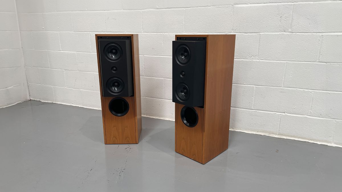 KEF Reference 104/2 floorstanding speakers on grey floor in front of white brick wall