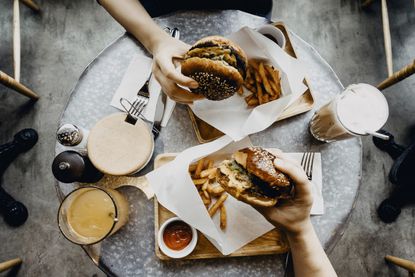 Avoid relationship weight gain: couple sharing burgers together