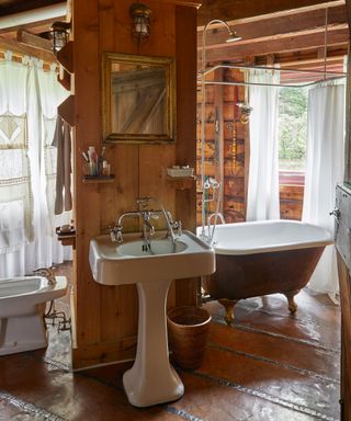 Period bathroom with freestanding bath in Isabella Rossellini's Long Island rustic barn