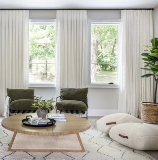 A living room with olive green chairs and white decor