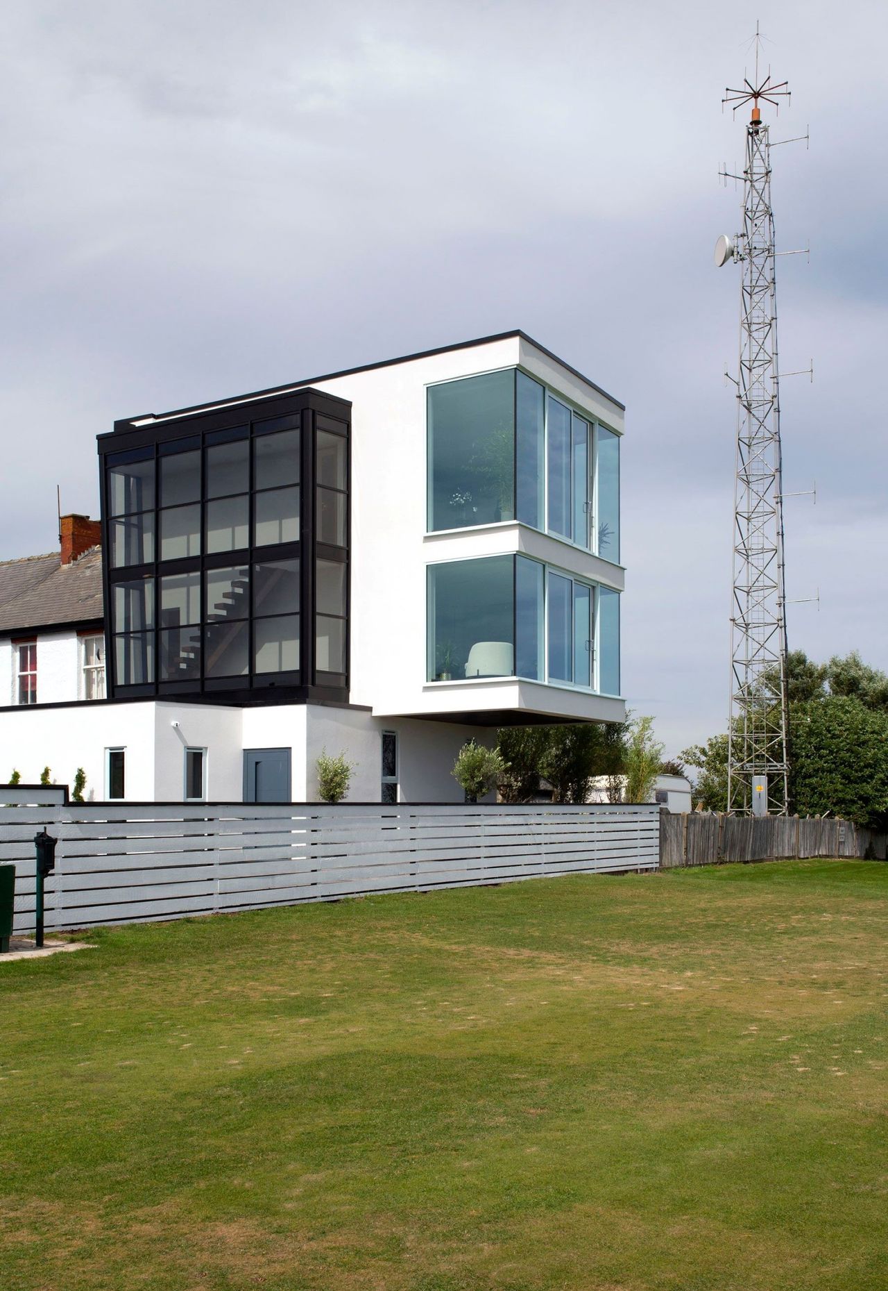 A white steel and glass box home on a coastal plot