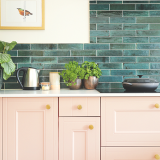 Pink kitchen cabinet with dark green tiles