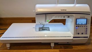 Best sewing machines; a large sewing machine, the Brother Innovis NV1800Q, on a wooden table