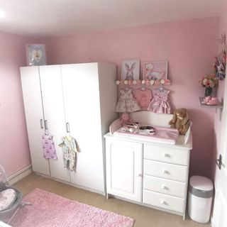 room with pink walls and white cupboard