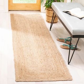 A flatweave jute rug next to a dining table and chairs