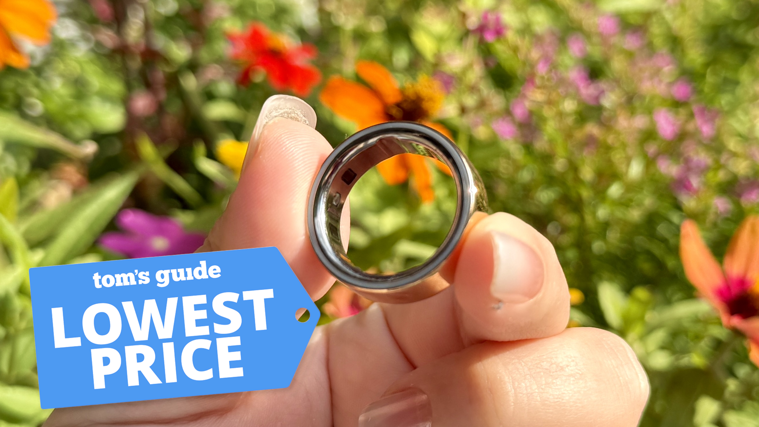 The Oura Ring 4 in hand outside with a Tom's Guide lowest price deals badge